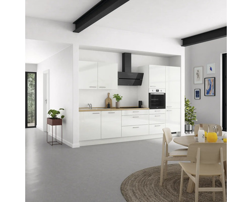 Helle Küche mit weißen Schränken, Dunstabzugshaube und Holzarbeitsplatte in einem geräumigen Raum.