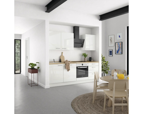 Helle Küche mit weißen Schränken, Dunstabzugshaube und Holzarbeitsplatte.