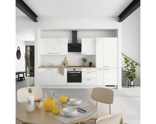 Moderne Küche mit weißen Schränken, Dunstabzugshaube und Holzarbeitsplatte in einem hellen Raum.