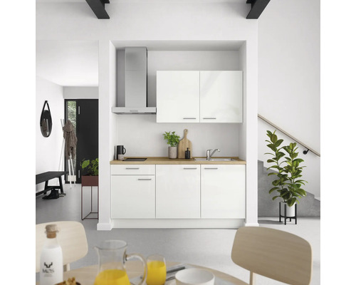 Einbauküche mit weißen Fronten, Dunstabzugshaube und Spüle in einem hellen Raum.