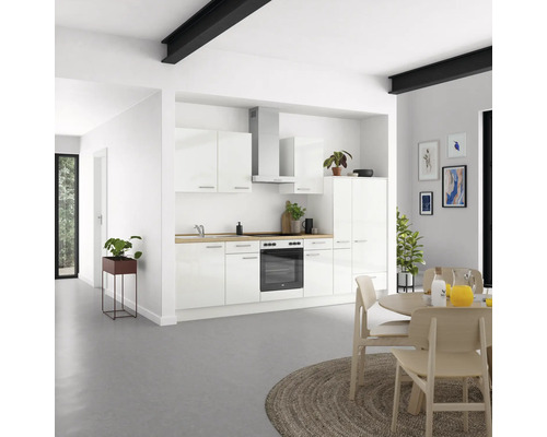 Heller Wohnraum mit Einbauküche in Weiß, Esstisch und Dekorationen.