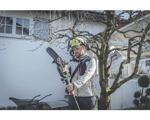 Mann mit Akku-Hochentaster bei der Gartenarbeit