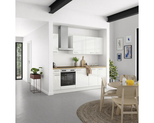 Helle Küche mit weißen Schränken, Dunstabzugshaube und Holzarbeitsplatte in einem modernen Haus.