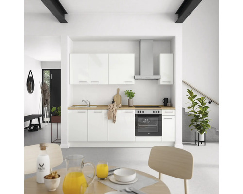 Helle Küche mit weißen Schränken, Spüle, Herd und Dunstabzugshaube in einem modernen Haus