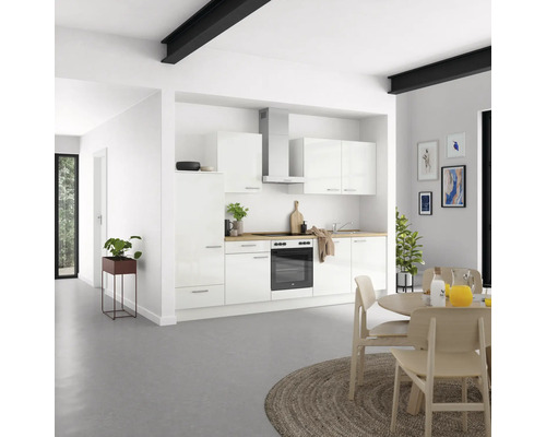 Moderne Küche mit weißen Schränken, Dunstabzugshaube und Holzarbeitsplatte in einem hellen Raum.