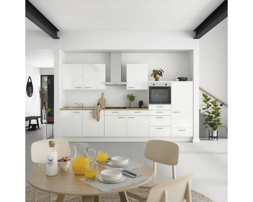 Helle Küche mit weißen Schränken, Dunstabzugshaube und Holzarbeitsplatte sowie Esstisch mit Geschirr