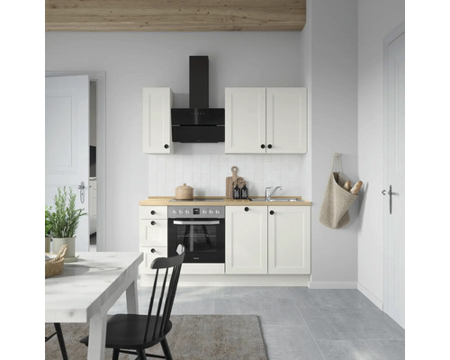 Küchenszene mit Einbauküche, Dunstabzugshaube, Spüle und Esstisch