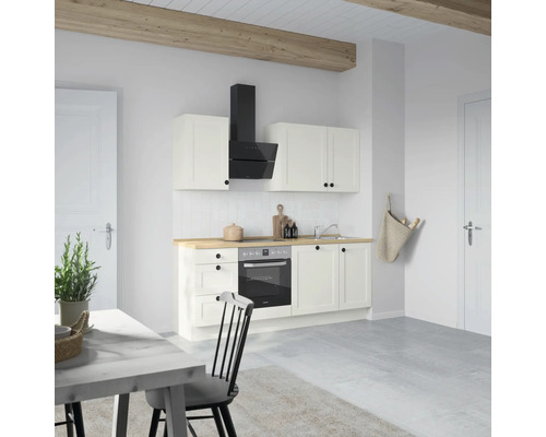 Helle Küche mit weißen Schränken, Dunstabzugshaube und Holzarbeitsplatte.