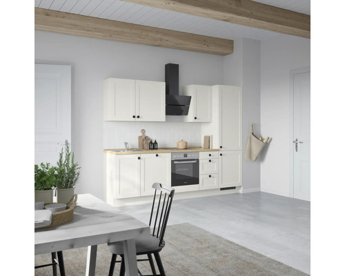 Helle Küche mit Küchenschränken, Dunstabzugshaube, Backofen und Holzbalken