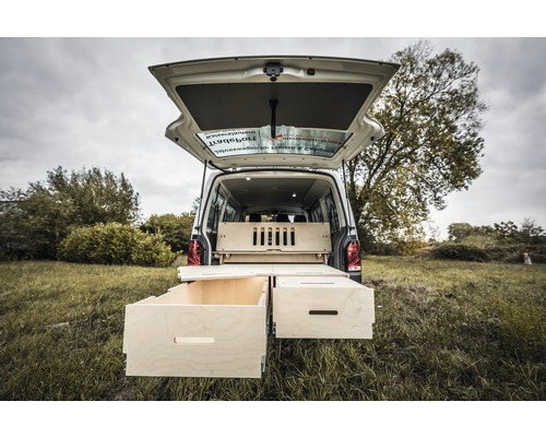 Heckansicht eines Lieferwagens mit ausziehbaren Holzschubladen und Regalsystem für Campingausrüstung.