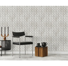 Wohnzimmer mit geometrischer Tapete, Sessel und Beistelltischen.