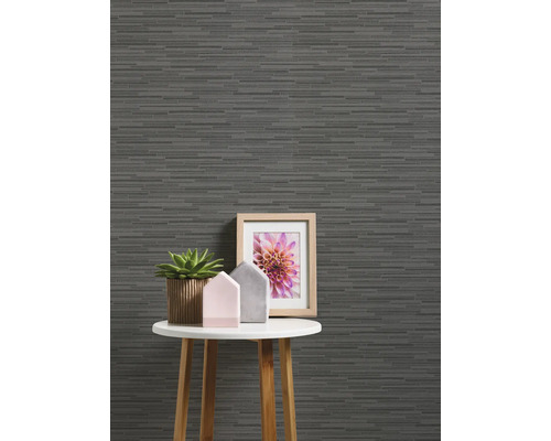 Dekorative Tapete mit horizontalem Streifenmuster auf einer Wand hinter einem kleinen Tisch mit Dekorationsgegenständen