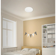 Schlafzimmer mit Bett, Regal und runder Deckenleuchte