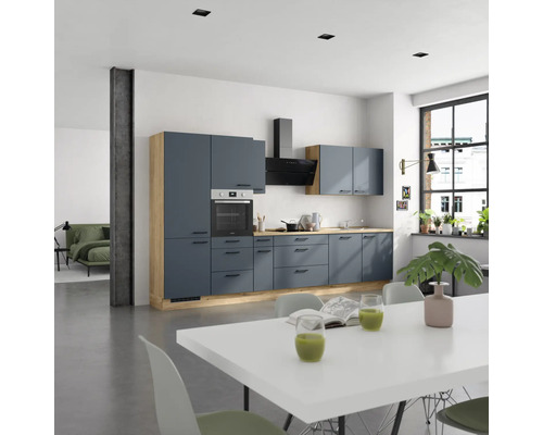 Helle Küche mit blauen Schränken, Spüle, Herd und Dunstabzugshaube in einem geräumigen Raum.