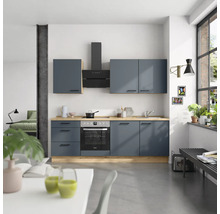 Moderne Küche mit blauen Schränken, Dunstabzugshaube und Holzarbeitsplatte in einem hellen Raum.
