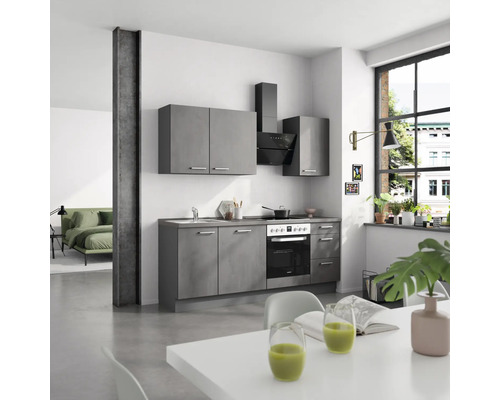 Graue Küchenzeile mit Spüle, Herd, Dunstabzugshaube und Hängeschränken in einem hellen Raum.