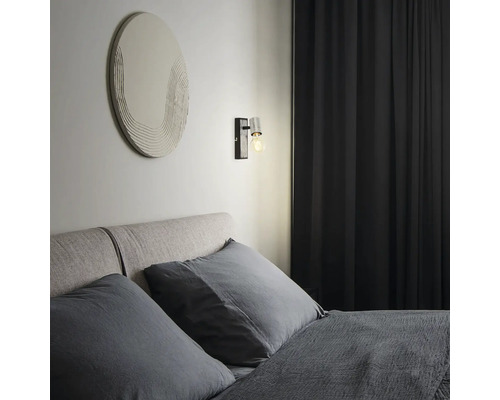 Schlafzimmer mit Bett, Wandleuchte und Dekor