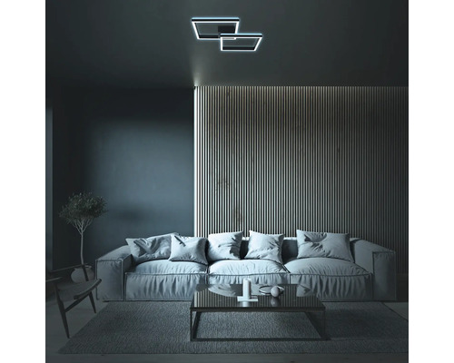 Wohnzimmer mit Sofa, Couchtisch und Deckenleuchte in geometrischem Design