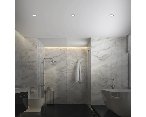 Helles Badezimmer mit Dusche, Badewanne, Toilette und Marmorfliesen.