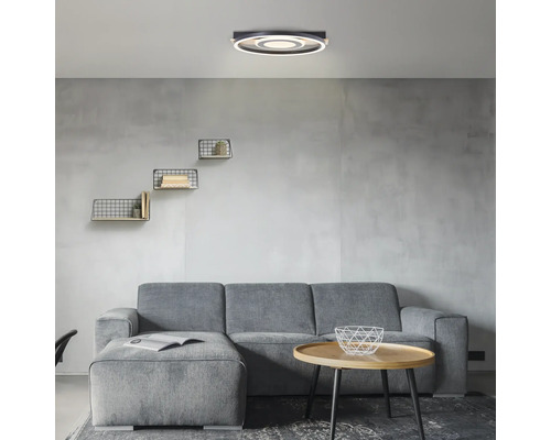 Wohnzimmer mit grauer Couch, Couchtisch und runder Deckenleuchte