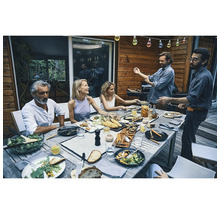 Gesellschaft beim Grillen im Freien mit zubereiteten Speisen auf dem Tisch
