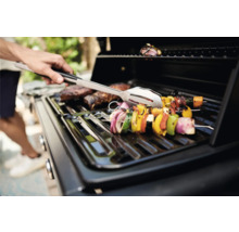 Grill mit Grillgut und Grillzange