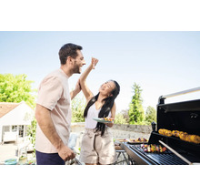 Mann und Frau grillen im Freien und essen Fleischspieße.