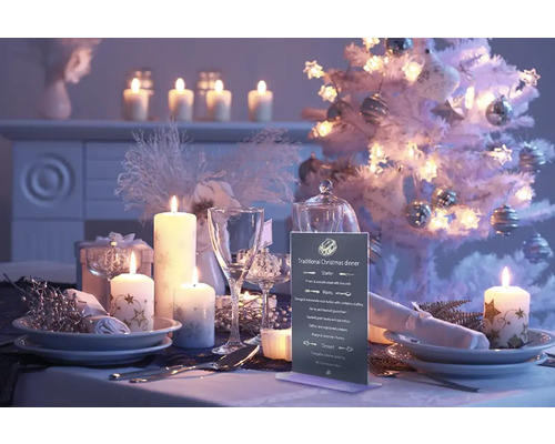 Festlich gedeckter Tisch mit Kerzen und Weihnachtsbaum für ein Weihnachtsessen