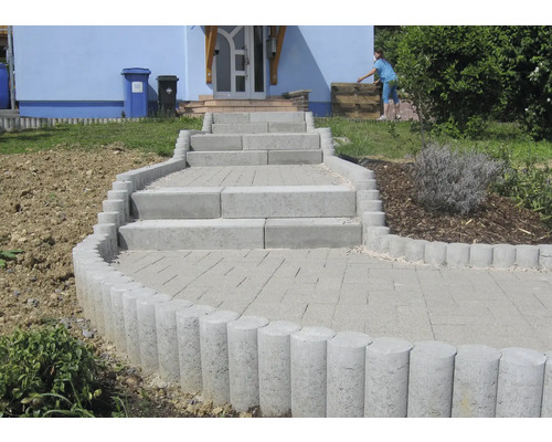 Außenaufnahme einer Treppe mit Betonpflastersteinen und Palisaden