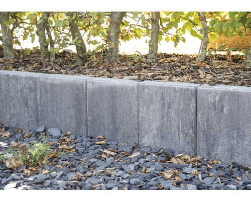 Gartenlandschaft mit grauen Rasenkantensteinen und Baumreihe