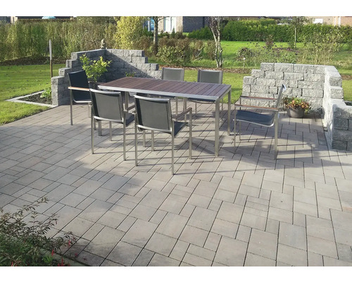 Gartenszene mit Esstisch, Stühlen und Steinpflaster