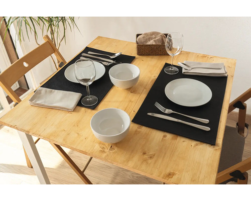 Gedeckter Esstisch mit Geschirr, Besteck und Tischsets für zwei Personen.