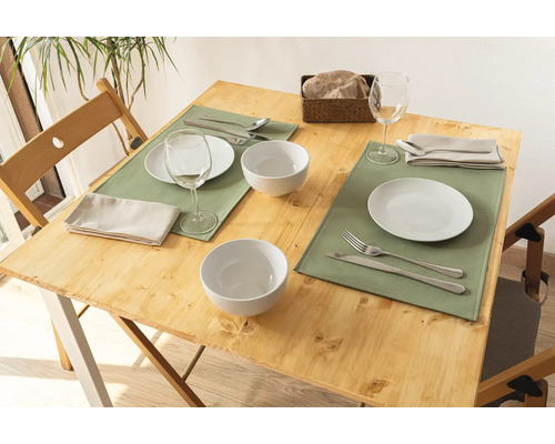 Gedeckter Holztisch mit Tellern, Schüsseln, Gläsern, Besteck und Servietten