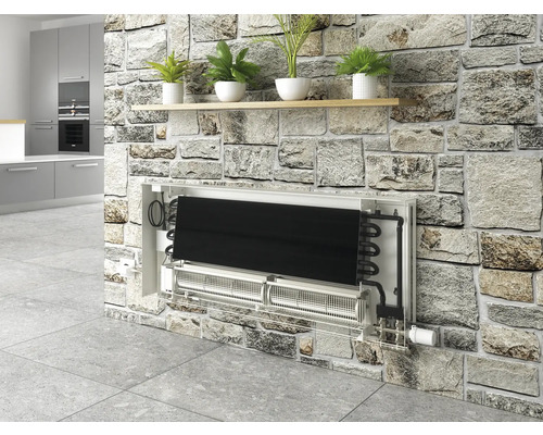 Installierter Wandkonvektor in einem Raum mit Natursteinwand und Pflanzenregal