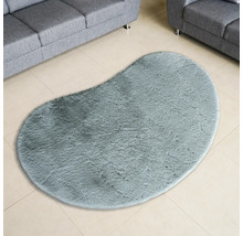 Ovaler Teppich mit hochflorigem Flor auf Fliesenboden