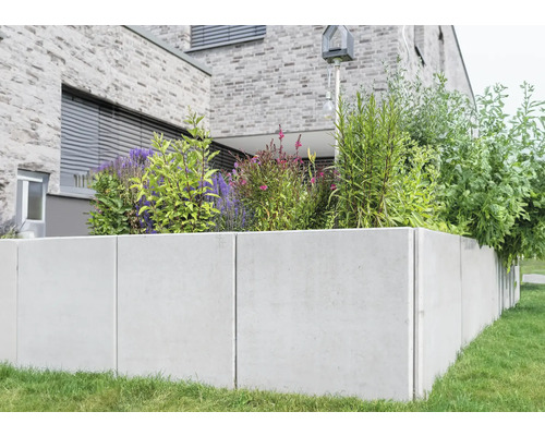 Hochbeet aus Beton mit Pflanzen vor einem Haus