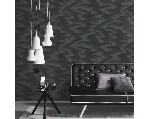 Raumansicht mit gemusterter Tapete, Sofa, Tisch und Hängeleuchten