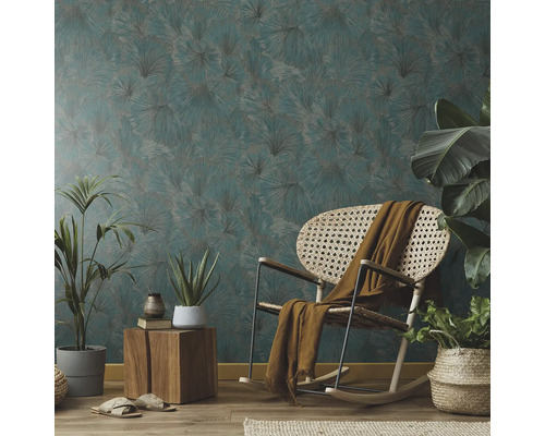 Wohnzimmer mit gemusterter Tapete, Schaukelstuhl und Zimmerpflanzen