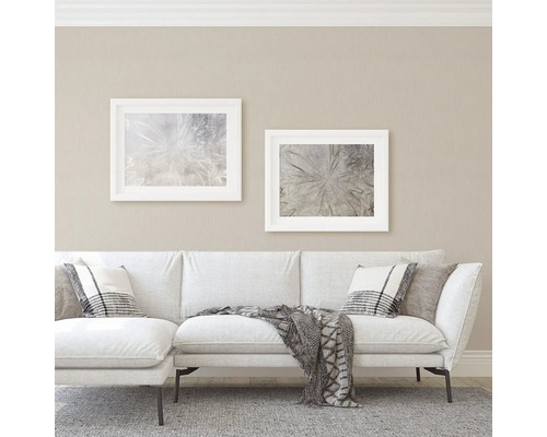 Wohnzimmer mit Sofa, Kissen und gerahmten Bildern an der Wand