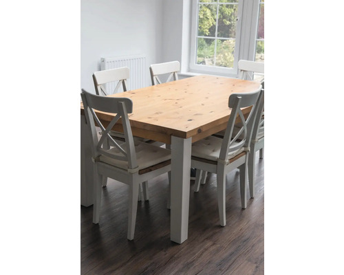 Esstisch mit Holzplatte und weißen Stühlen in einem hellen Raum