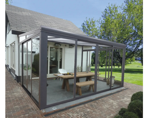 Modernes Glashaus mit Tisch und Bank im Garten