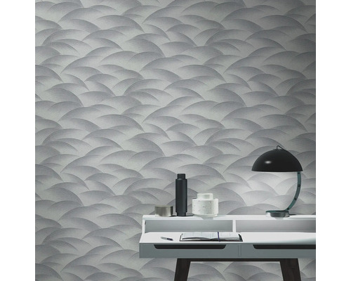 Raumansicht mit gemusterten Tapeten, Schreibtisch und Lampe