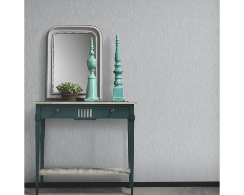 Dekoratives Interieur mit Tisch, Spiegel und Ornamenten vor einer Wand mit Tapete