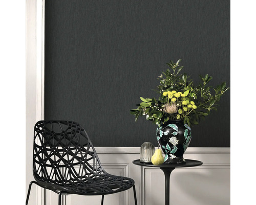 Szene mit strukturierten Tapeten, einem Stuhl, einem Tisch mit Blumenvase und Dekorationsgegenständen.