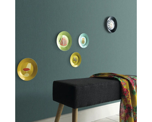 Wanddekoration mit Ziertellern und eine Bank