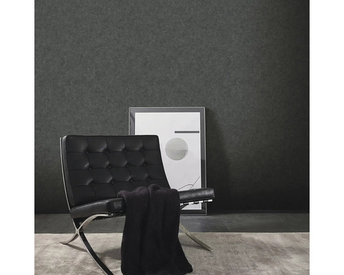 Wohnszene mit dunkler Vinyltapete, Sessel und gerahmtem Bild