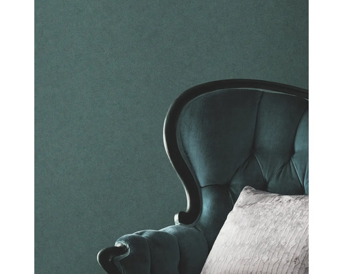 Nahaufnahme eines gepolsterten Sessels mit Kissen vor einer Wand