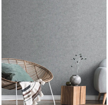 Graue Wandgestaltung mit Sessel, Beistelltisch und Sofa im Wohnzimmer.