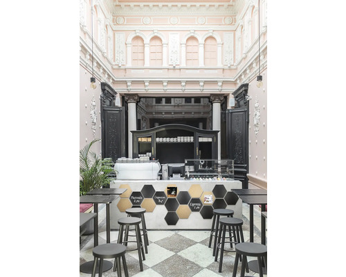 Innenraumansicht eines Cafés mit Tischen, Stühlen und Theke.