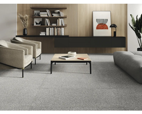 Wohnzimmer mit Terrazzoboden, Sesseln, Couchtisch und Regalen